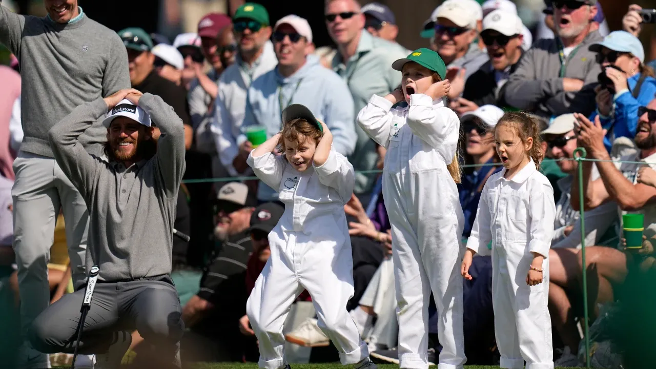 Tommy Fleetwood (jongkok kiri) dan anak-anaknya bereaksi saat bola Frankie Fleetwood nyaris memasuki area green dari jarak 120 yard. (Foto: Golf Digest)