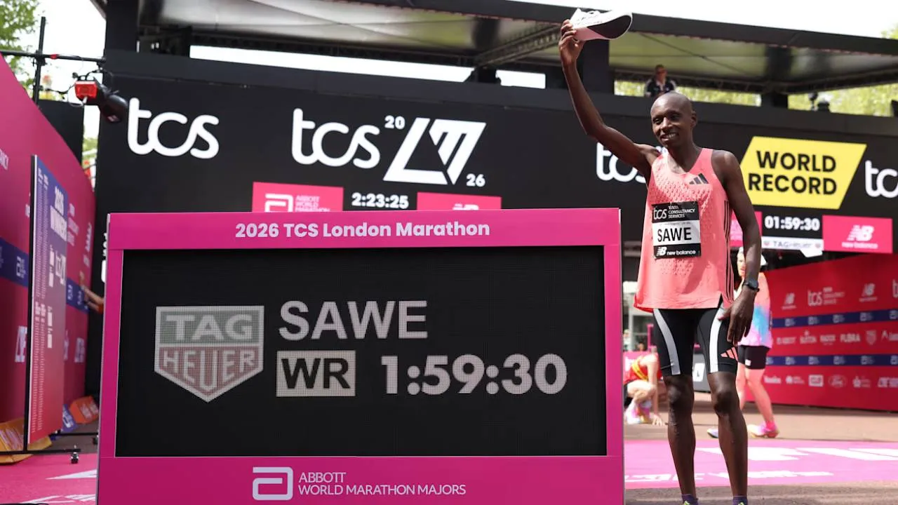 Sabastian Sawe (kanan) berpose dengan papan pencatat waktu yang memperlihatkan catatan waktunya yang memecahkan rekor dunia. (Foto: AP)