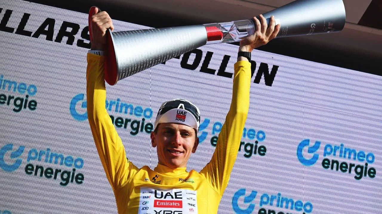 Tadej Pogacar melakukan selebrasi dengan mengangkat trofi juara Tour de Suisse di atas podium. (Foto: AP)