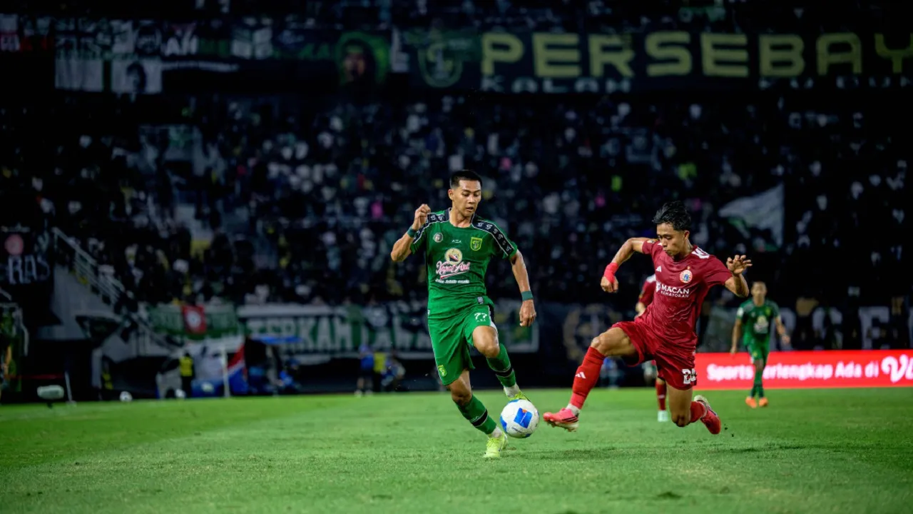 Pemain Persebaya Surabaya, Malik Risaldi berupaya melewati pemain Persija Jakarta