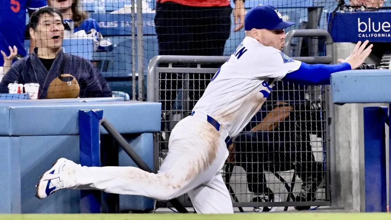 Freddie Freeman mengejar bola, tetapi salah memperkirakan posisi pagar sebelum tubuhnya terjatuh melewati tangga dan masuk ke area bangku pemain. (Foto: AP)