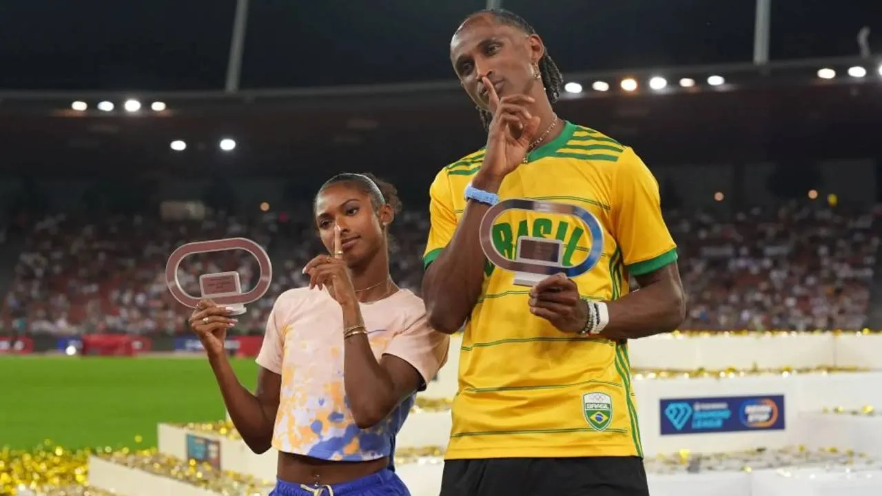 Masai Russell (kiri) dan Alison dos Santos berpose dengan trofi kemenangan mereka di Diamond League di Zurich. (Foto: AP)