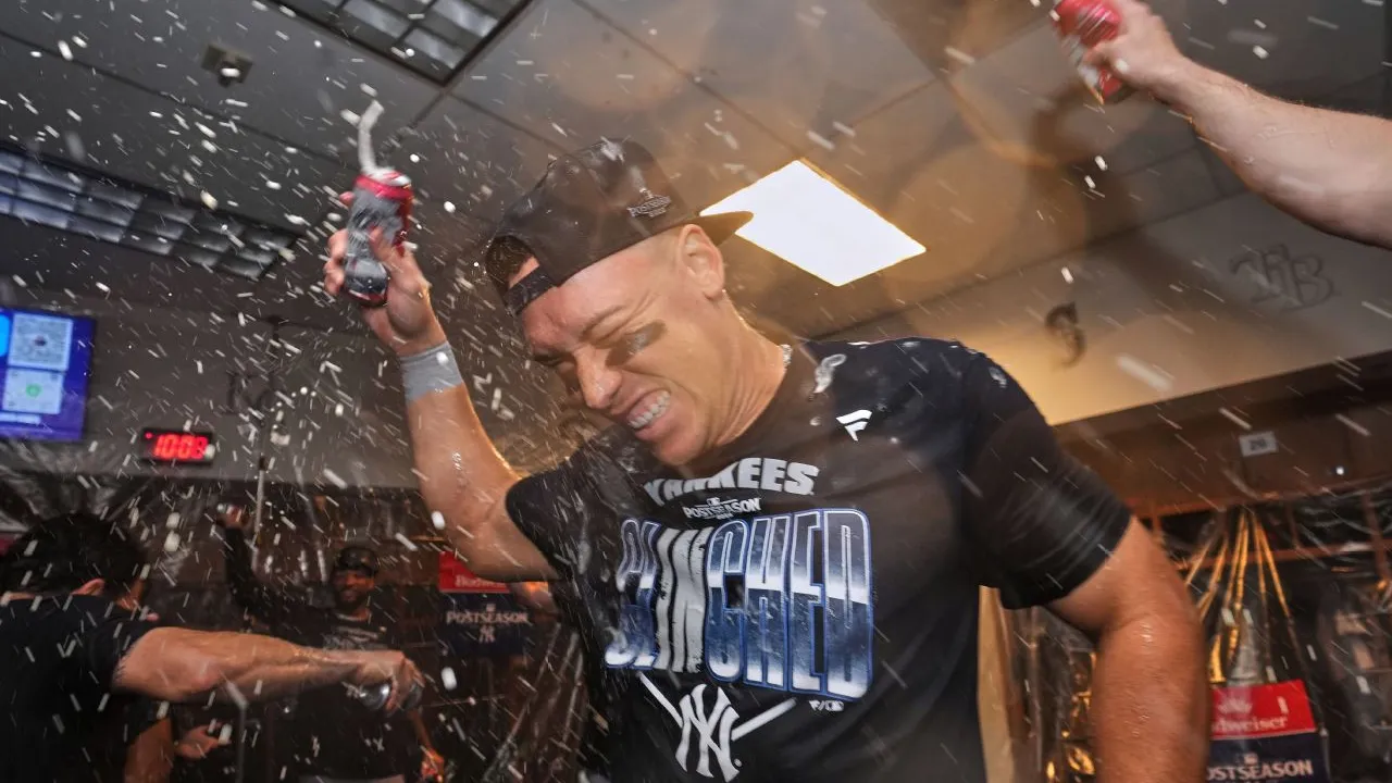 Aaron Judge melakukan selebrasi bersama pemain New York Yankees lainnya di ruang Ganti setelah memastikan tiket ke playoff. (Foto: AP)