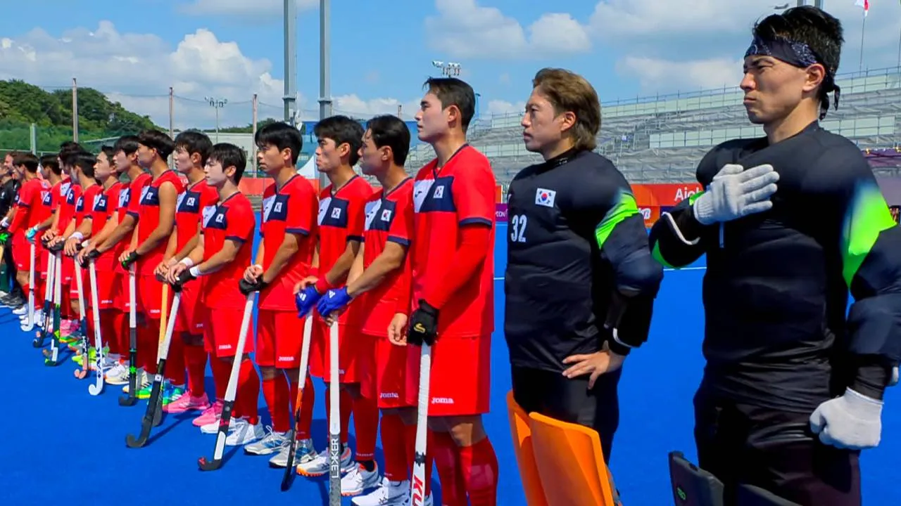 Para pemain Korea Selatan terlihat tidak yakin bagaimana harus merespons ketika lagu kebangsaan Korea Utara mulai terdengar jelang laga mereka di Asian Games. (Foto: AP)